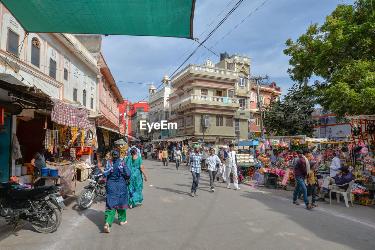 PEOPLE ON STREET BY BUILDINGS IN CITY