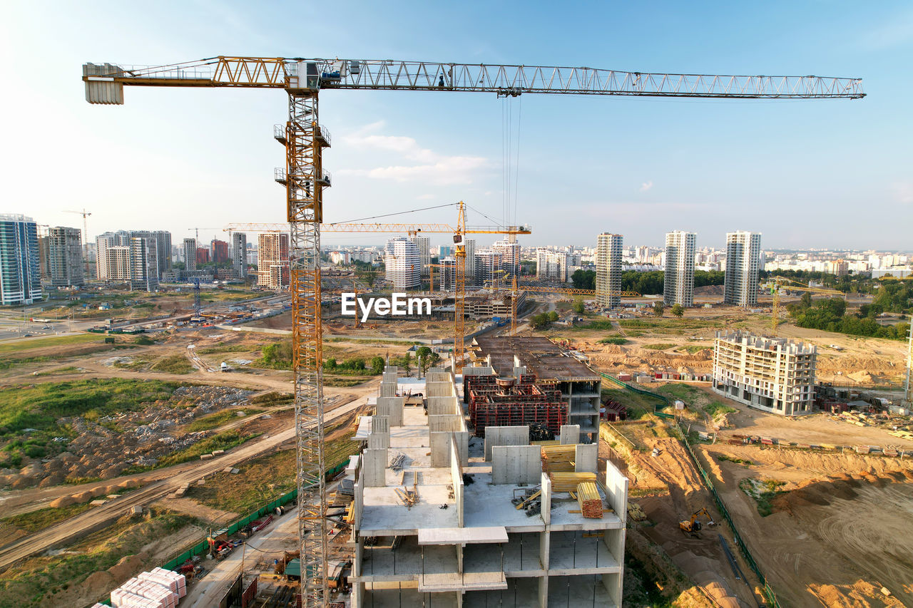 HIGH ANGLE VIEW OF CRANES AGAINST SKY