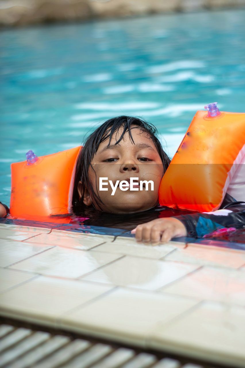 Portrait of young woman swimming in pool