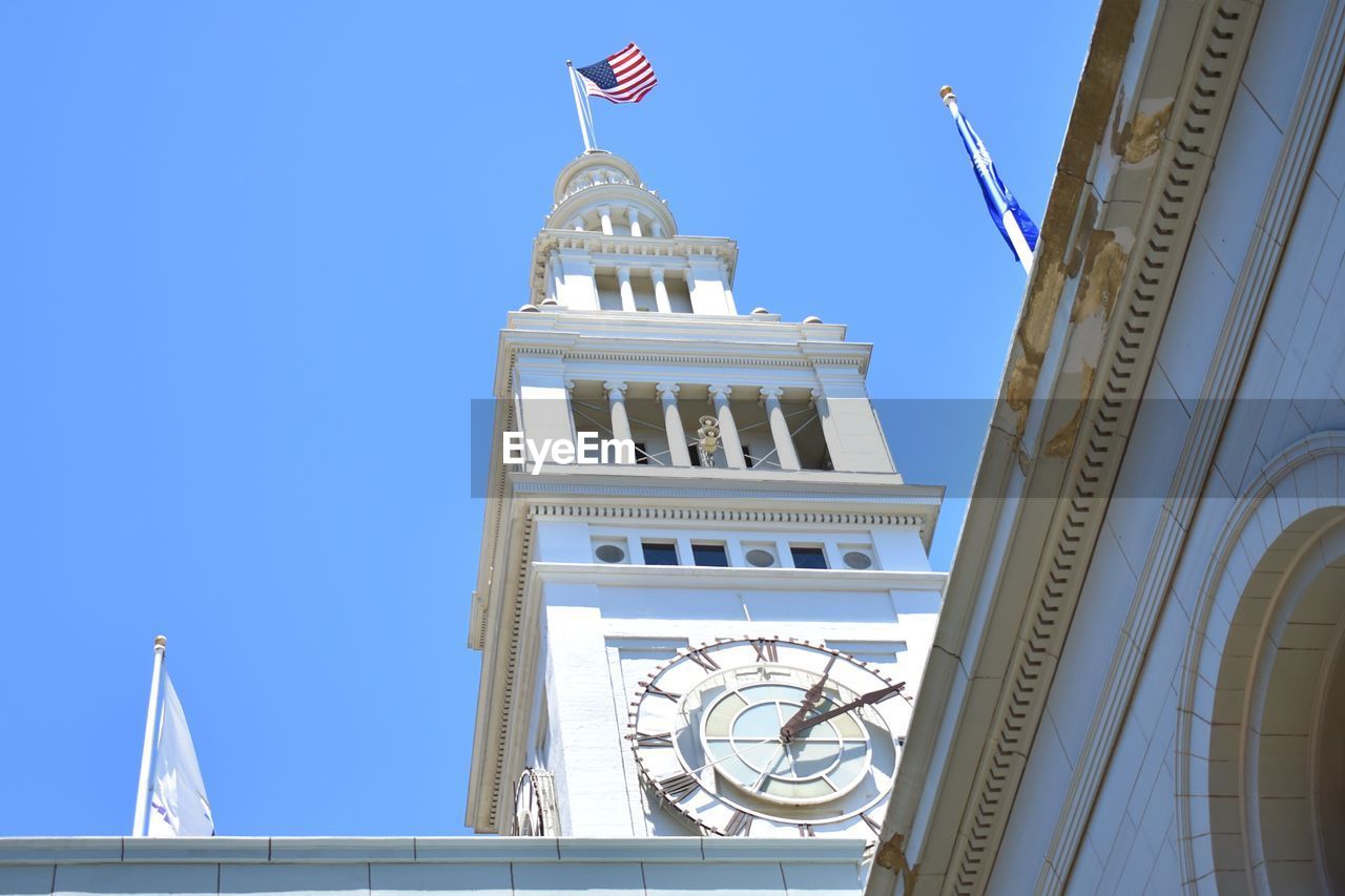 LOW ANGLE VIEW OF CLOCK TOWER AGAINST CLEAR BLUE SKY