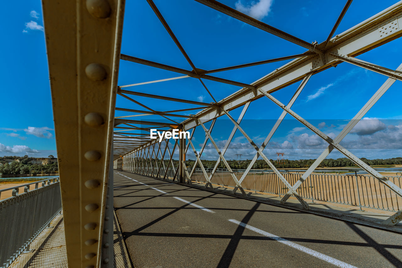 Metal bridge against blue sky with diminishing perspective