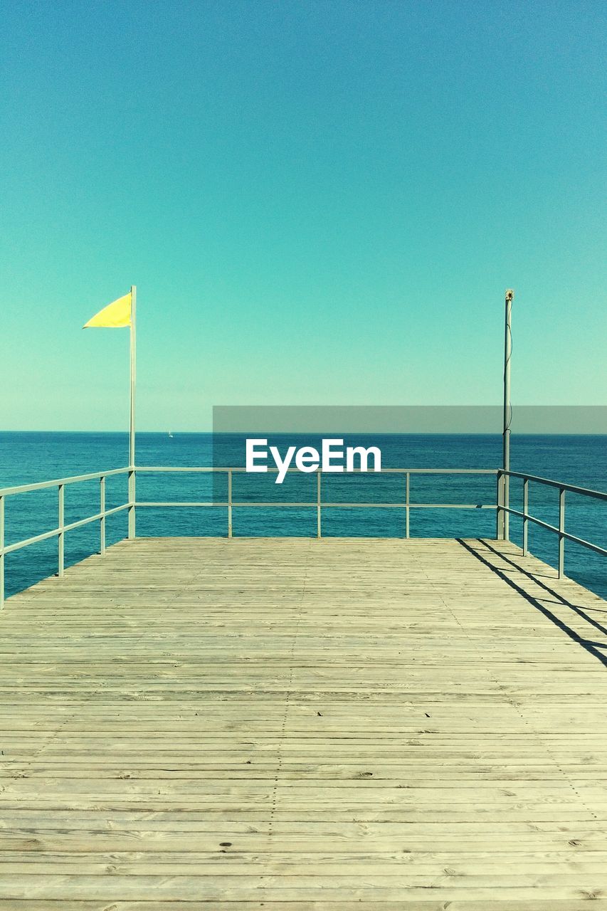 Scenic view of beach against clear blue sky