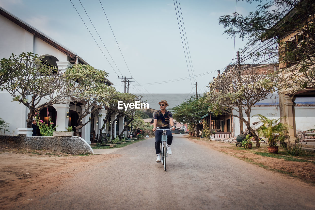 MAN RIDING BICYCLE ON ROAD