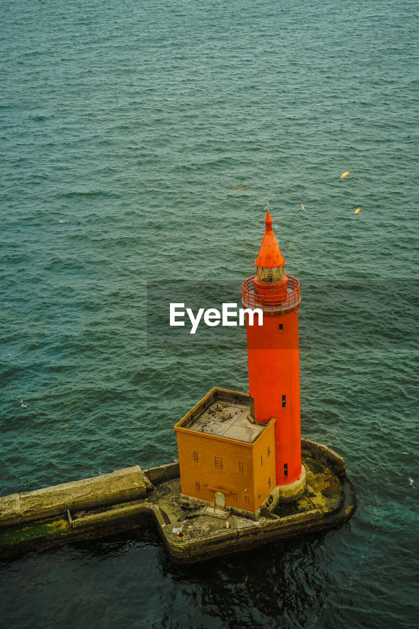 HIGH ANGLE VIEW OF RED CONTAINER SHIP IN SEA