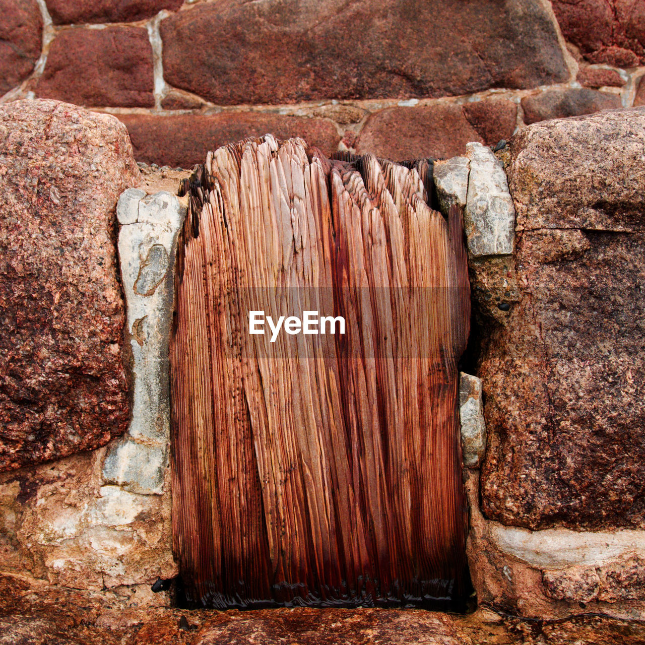 CLOSE-UP OF ROCK ON STONE WALL