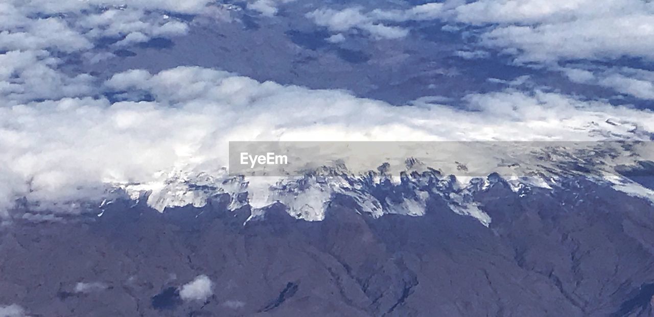 AERIAL VIEW OF SNOW COVERED MOUNTAINS