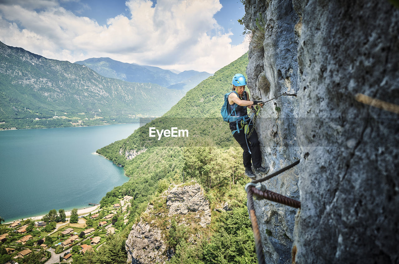 Woman wearing safety equipment climbing mountain