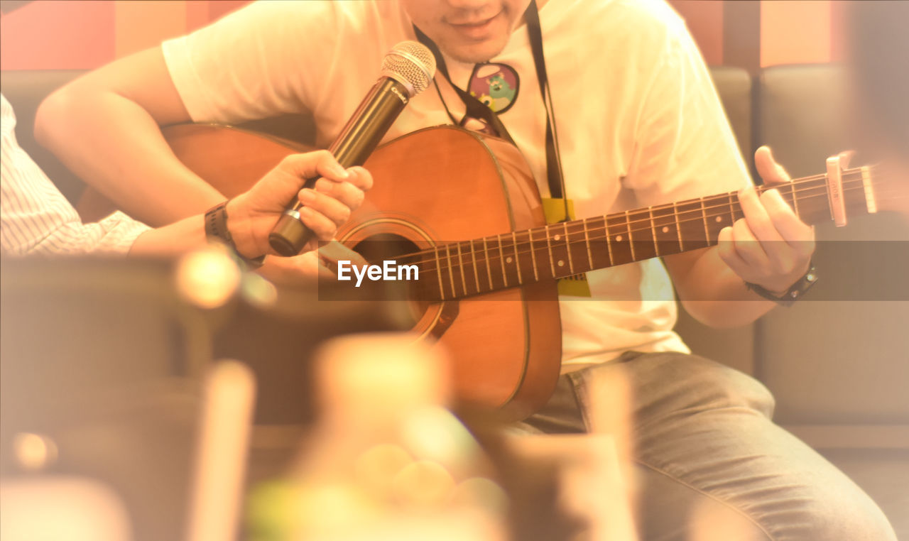 Music, men playing guitar in small party.