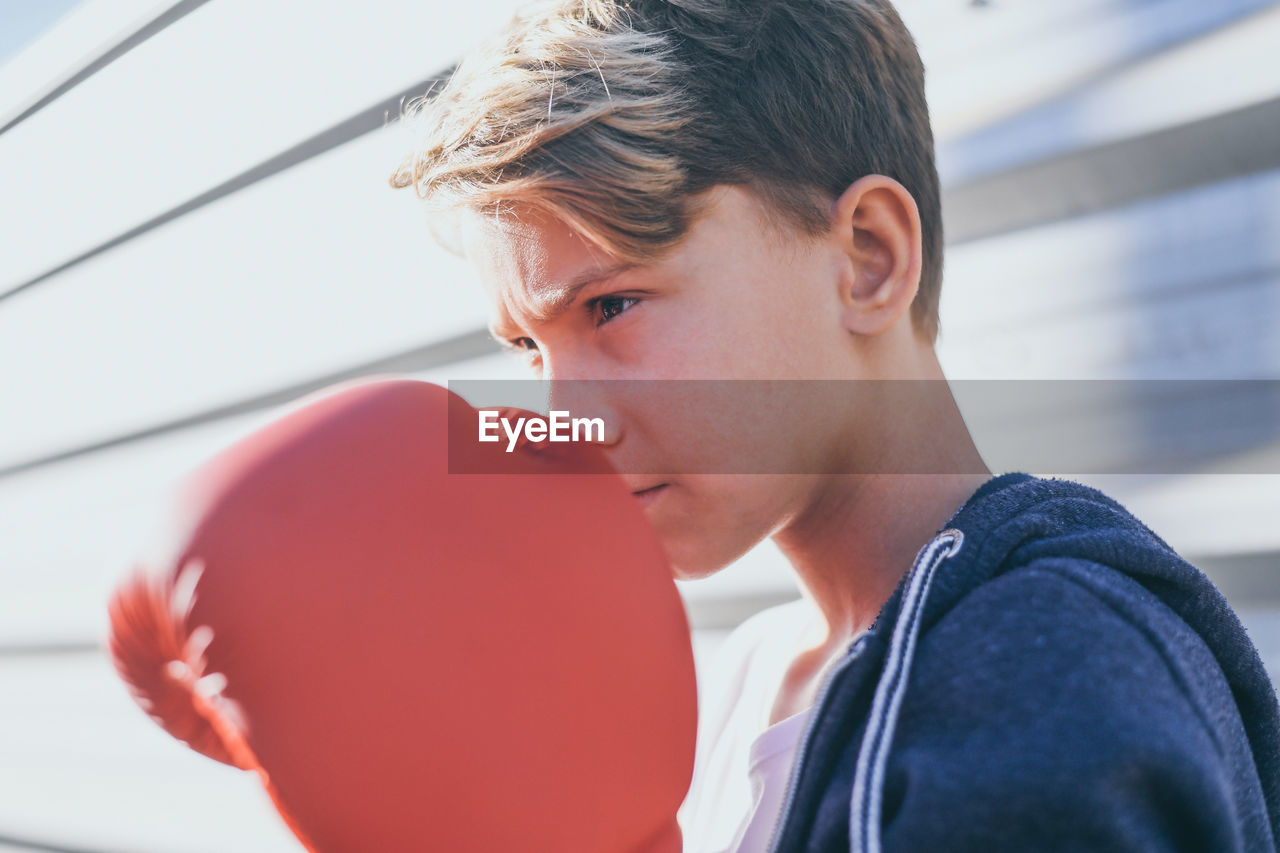 Close-up of boy wearing boxing glove