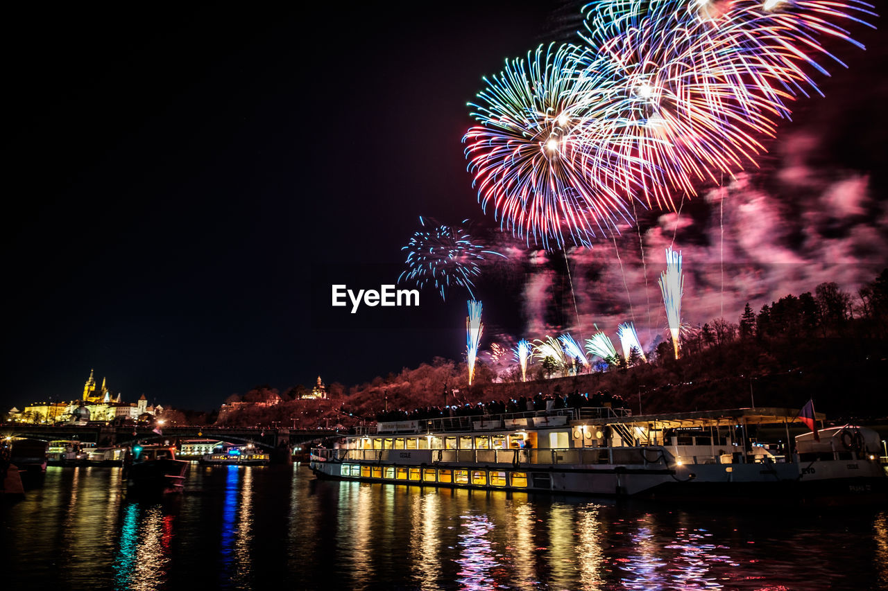 FIREWORK DISPLAY OVER RIVER AGAINST SKY