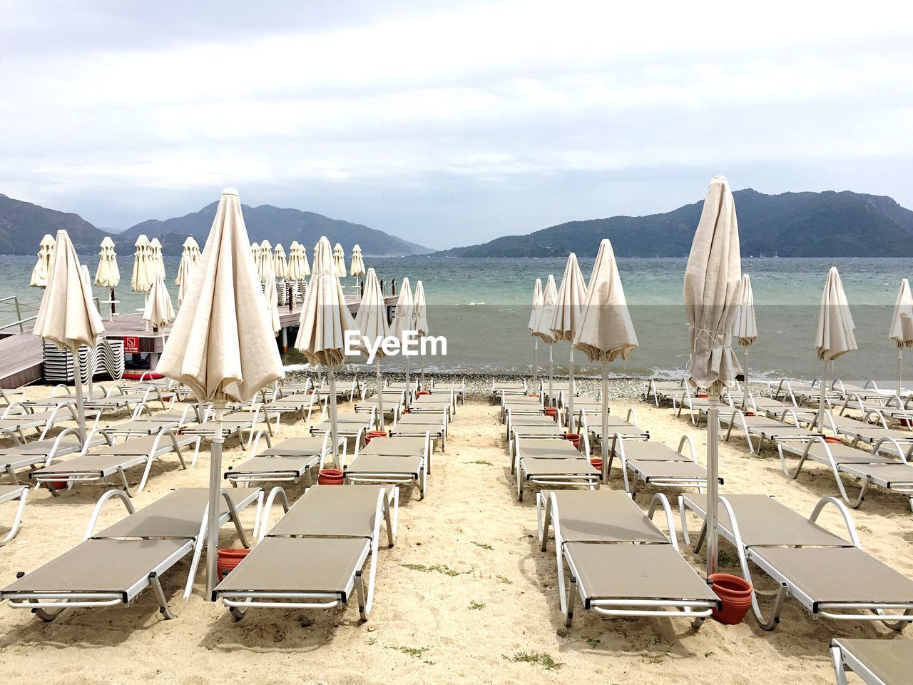 Lounge chairs and closed parasols at beach