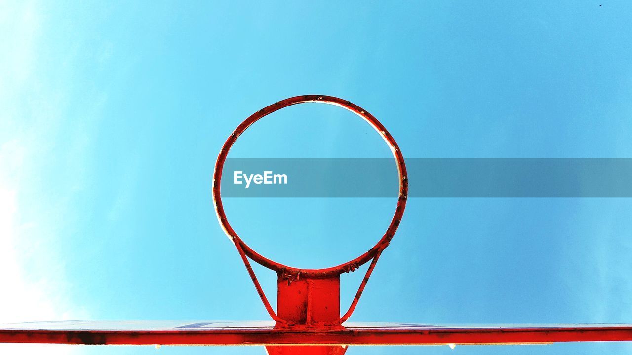 Close-up of basketball hoop against blue sky