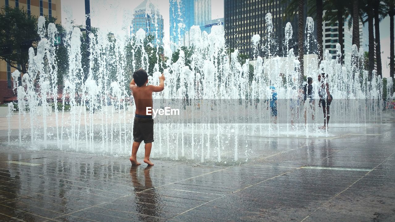 Full length of boy standing by fountain