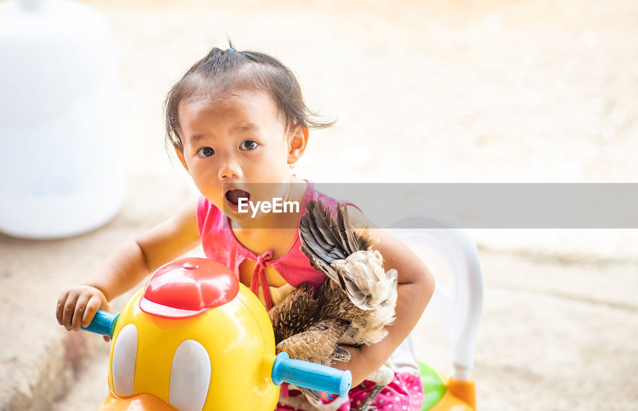 Portrait of cute baby girl with toy at park