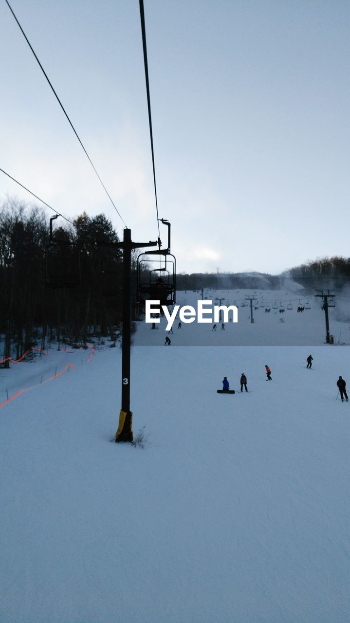 SKI LIFT OVER SNOW COVERED MOUNTAINS