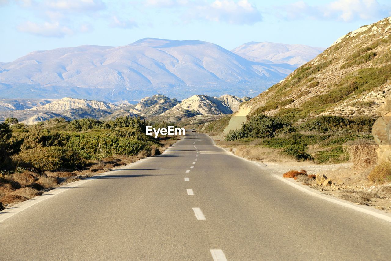 Road amidst mountains against sky