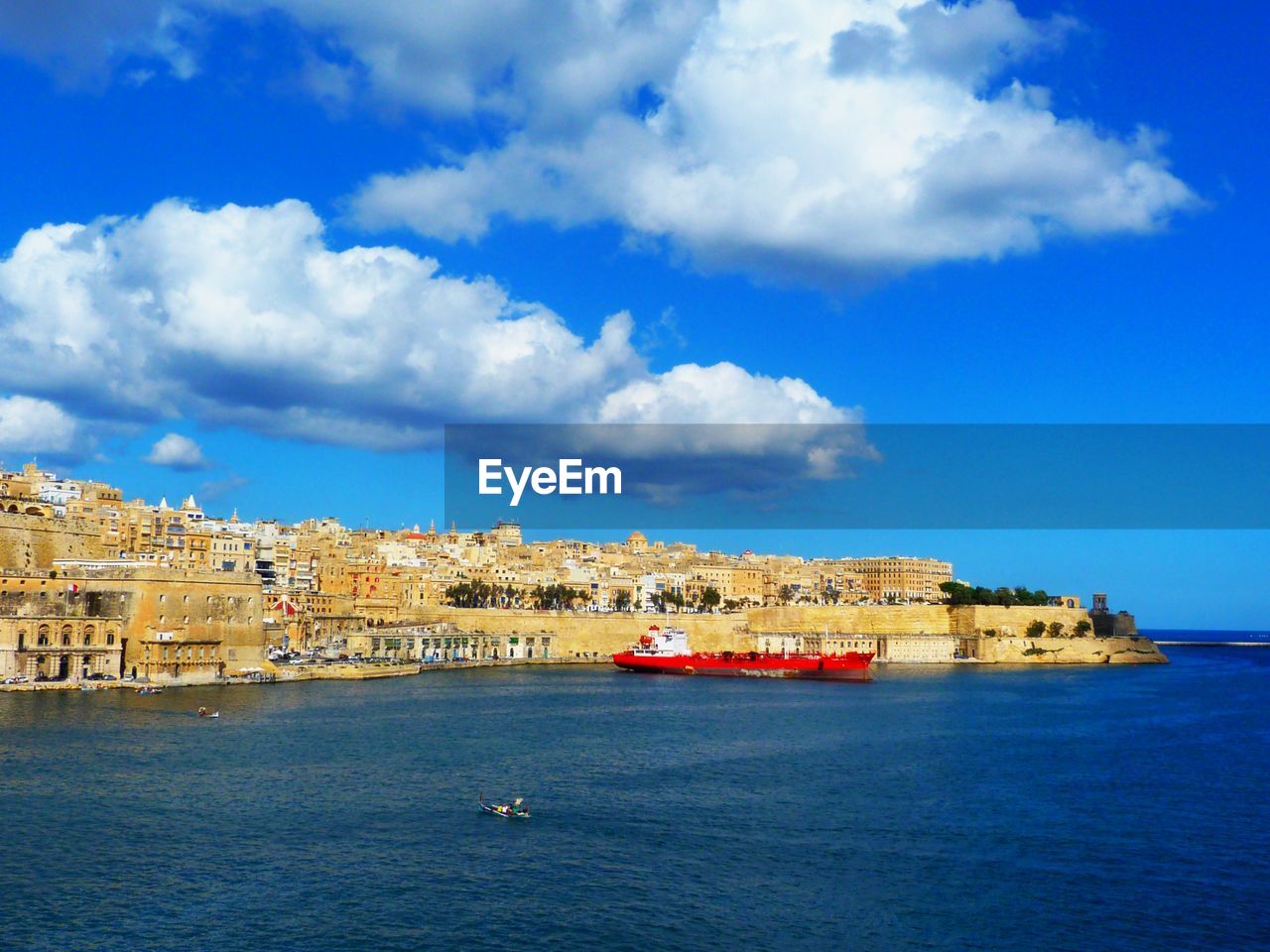 SCENIC VIEW OF SEA AND BUILDINGS IN CITY