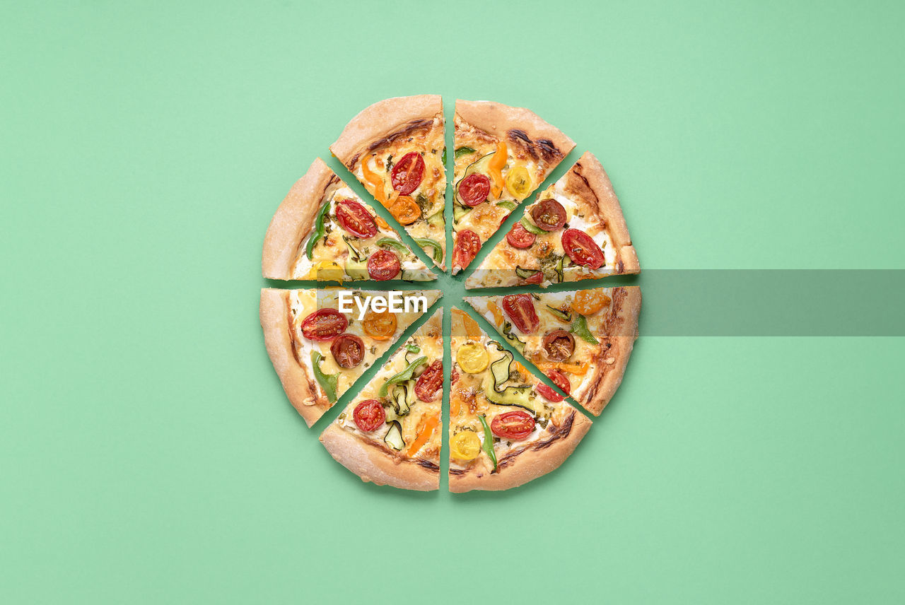 HIGH ANGLE VIEW OF PIZZA ON TABLE AGAINST GRAY BACKGROUND