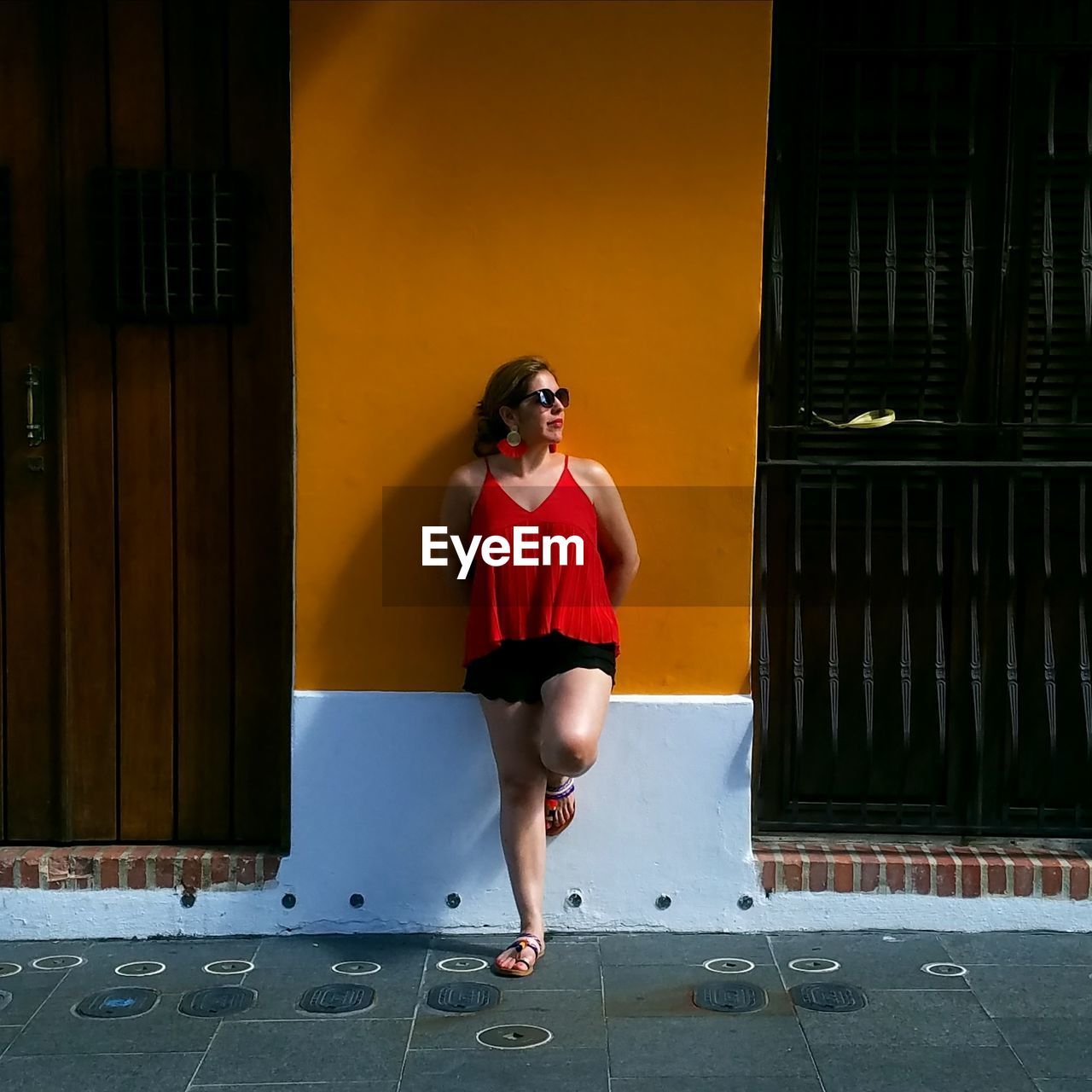 Full length of woman standing against building