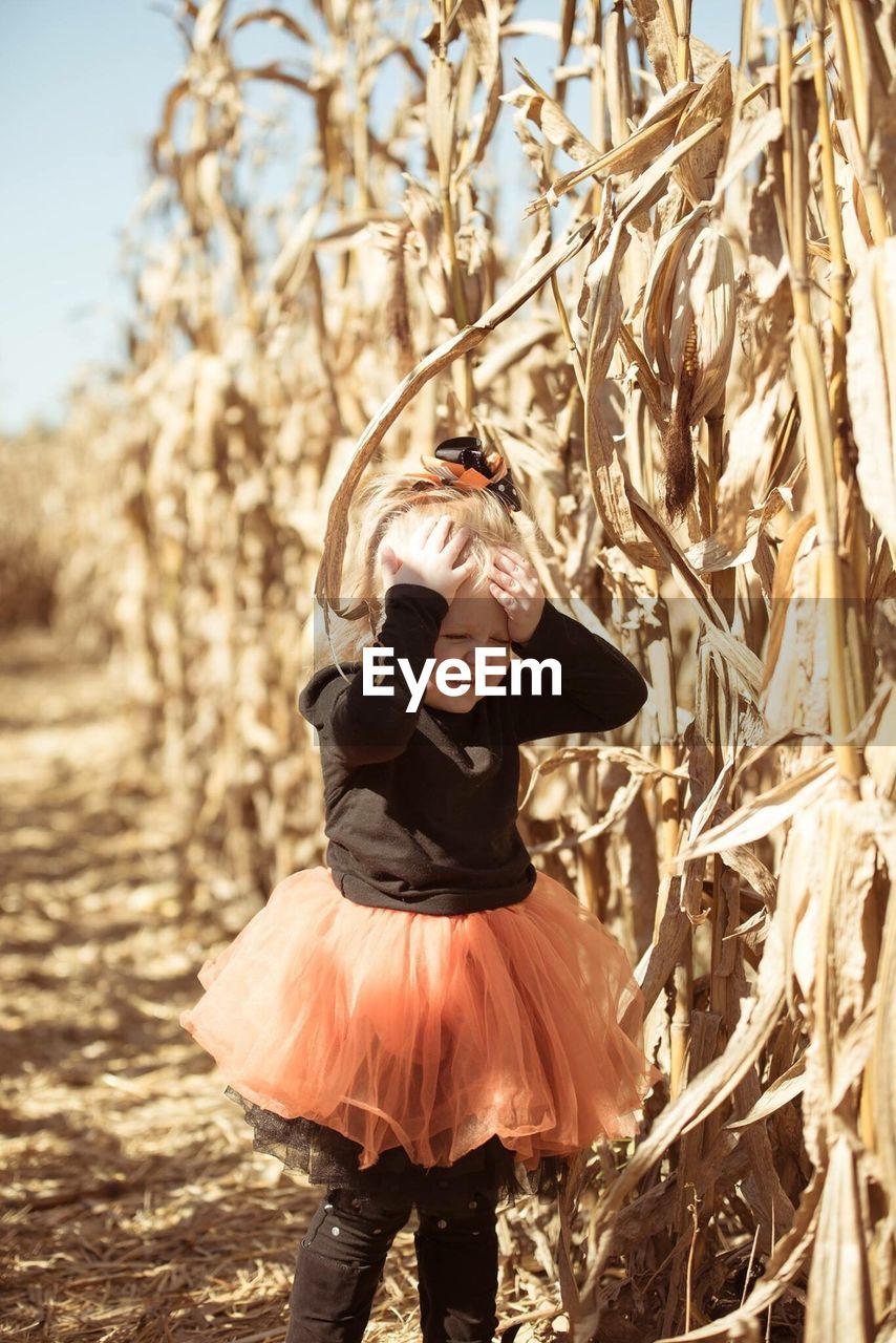 Girl wearing tutu standing at farm during sunny day