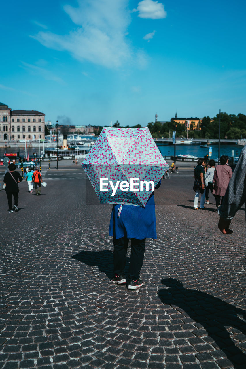 PEOPLE WALKING ON STREET IN CITY