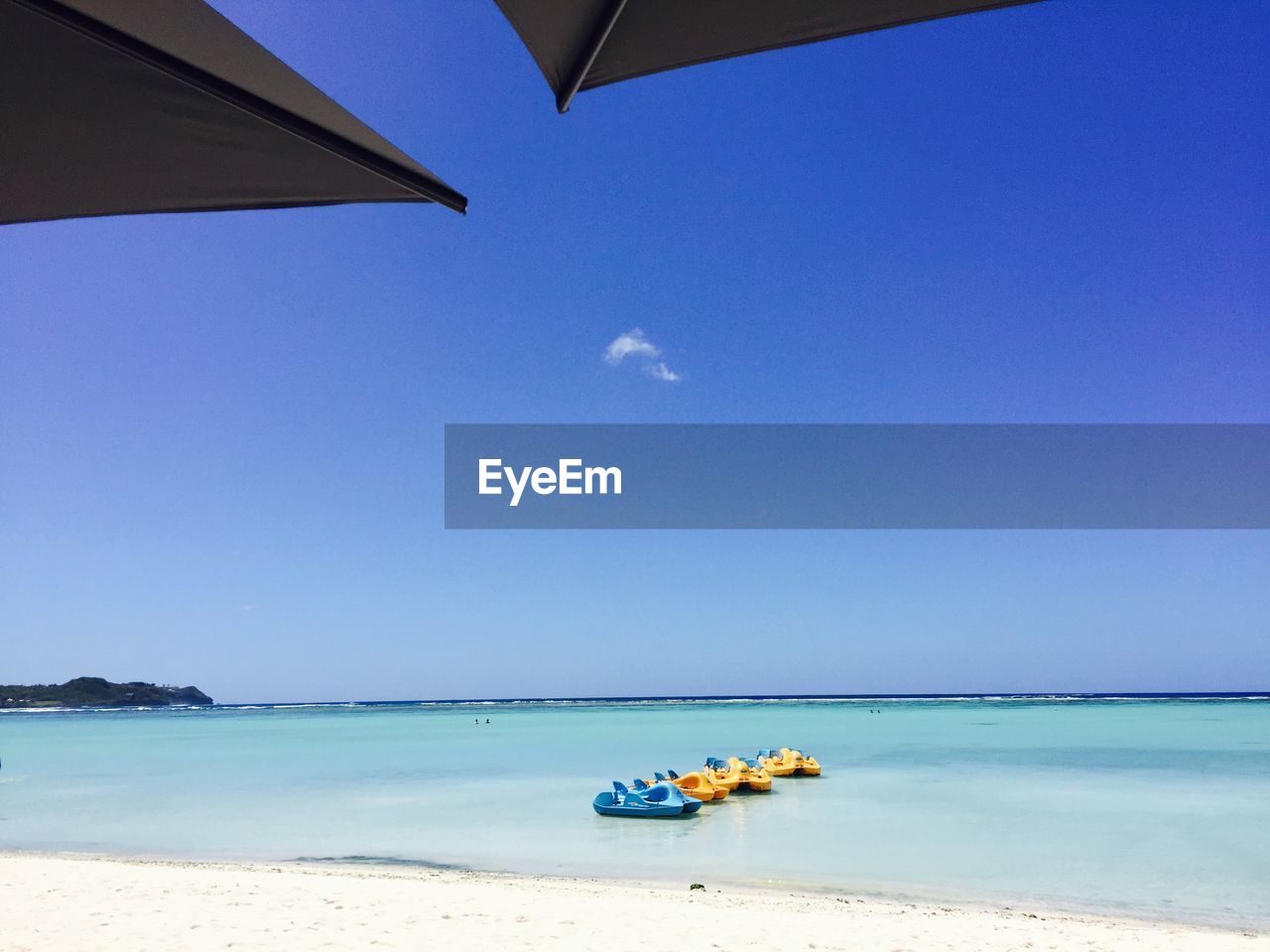 Boat on beach against clear blue sky