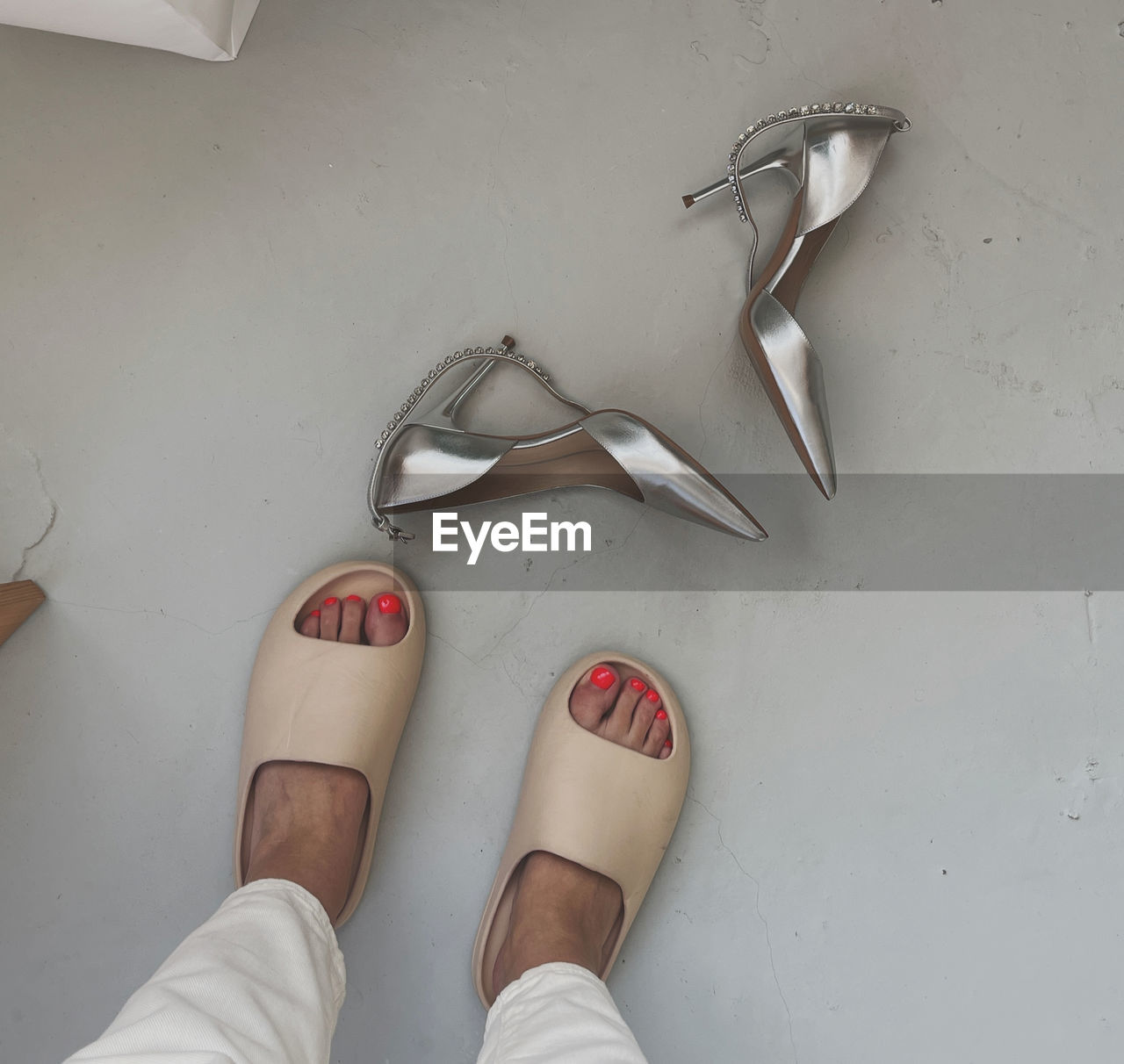 shoe, human leg, footwear, low section, one person, white, limb, indoors, sandal, personal perspective, adult, fashion, hand, human limb, lifestyles, high angle view, finger, women, human foot, arm, standing, directly above, flooring, pair, high heels, glasses, red