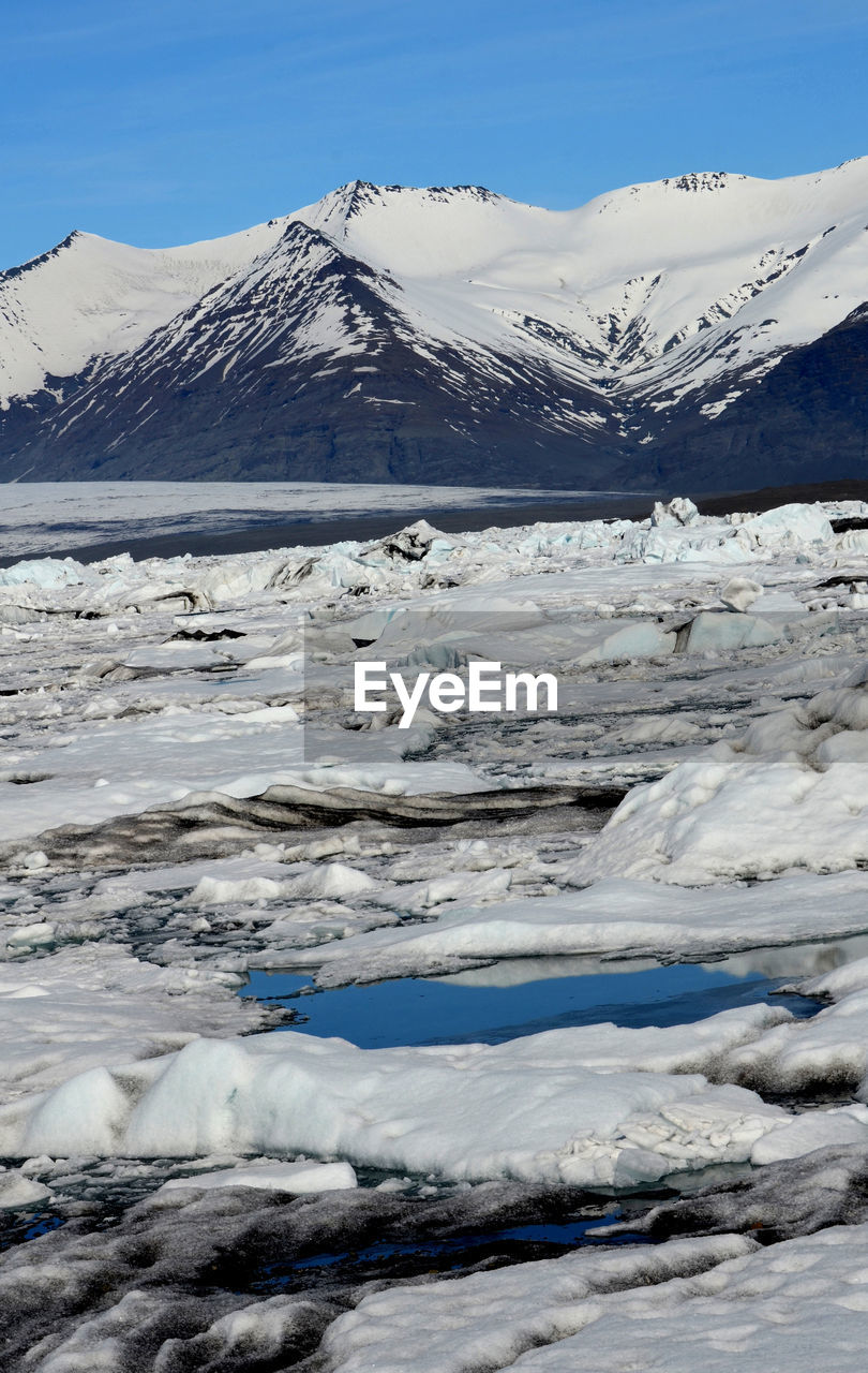 The summer thaw with glaciers and snow capped mountain peaks in iceland.