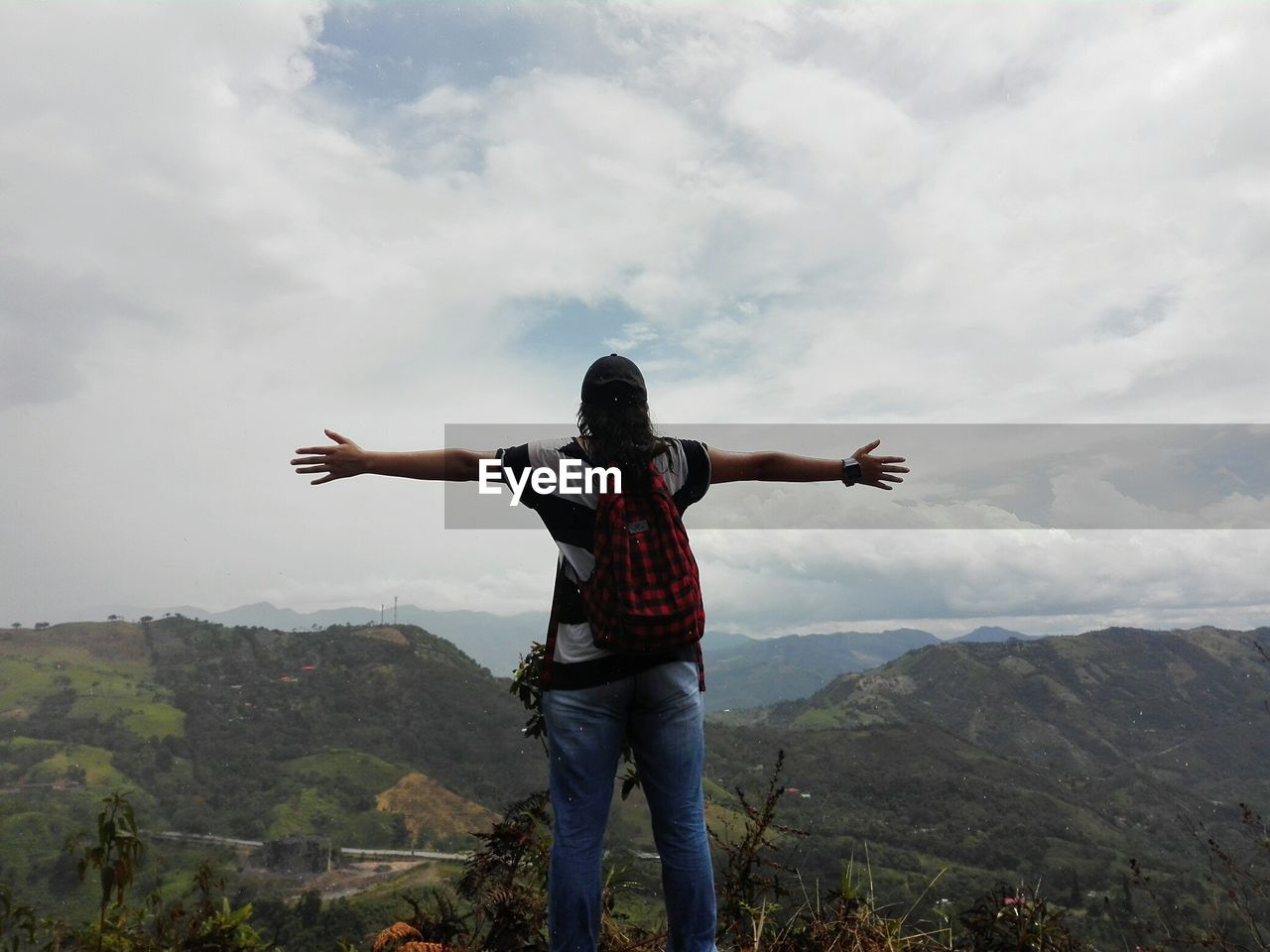 Woman standing on mountain against sky