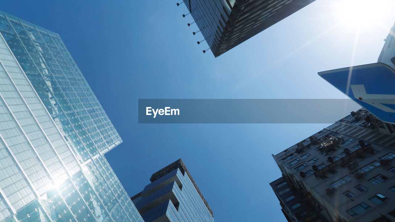 Low angle view of modern buildings against clear blue sky