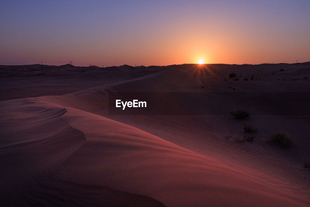 Scenic view of desert against sky during sunrise