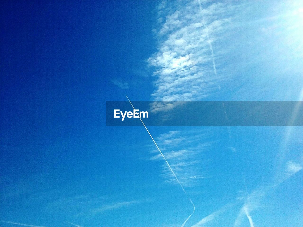 Low angle view of vapor trails in blue sky