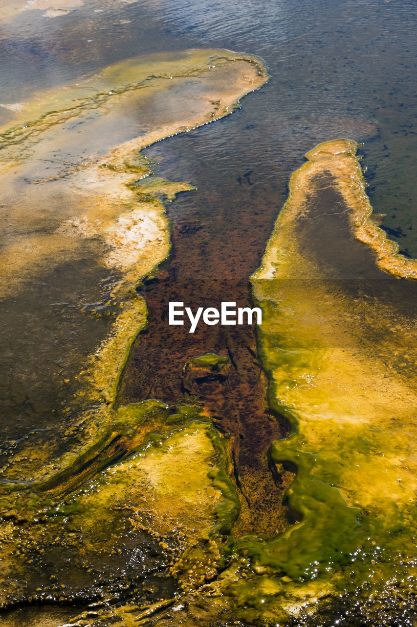 HIGH ANGLE VIEW OF STREAM FLOWING THROUGH LAND