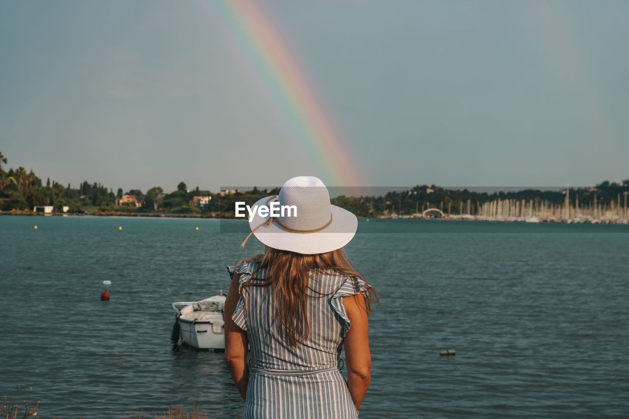 Rear view of a woman watching sea and rainbow