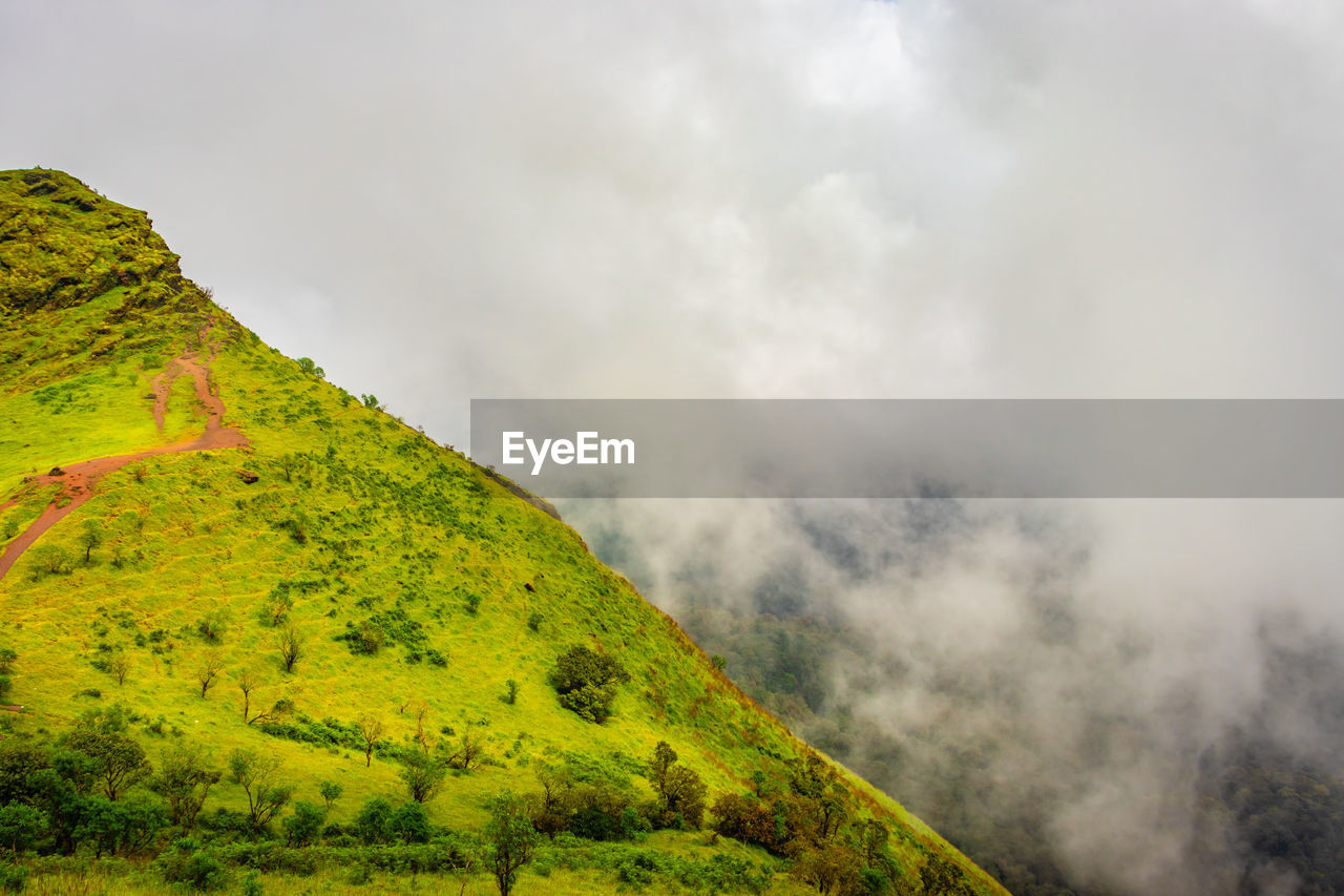 Mountain with green grass and amazing sky image is showing the amazing beauty