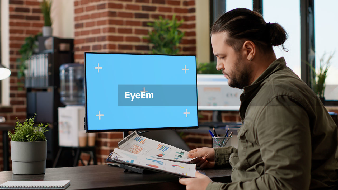 side view of man using laptop at office