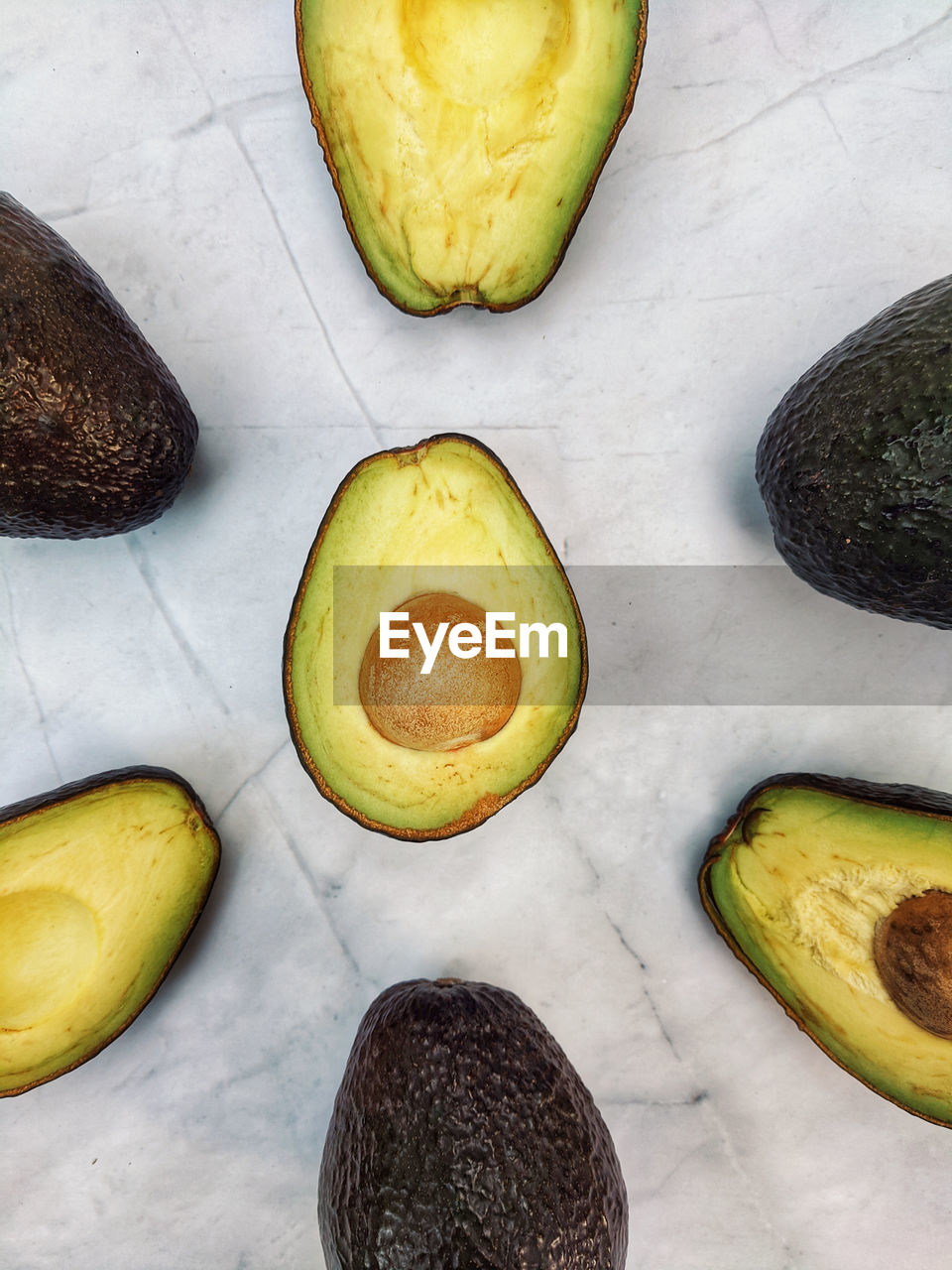 Fresh avocado with herbs and lemons lies on the table on white background. flat lay. top view.