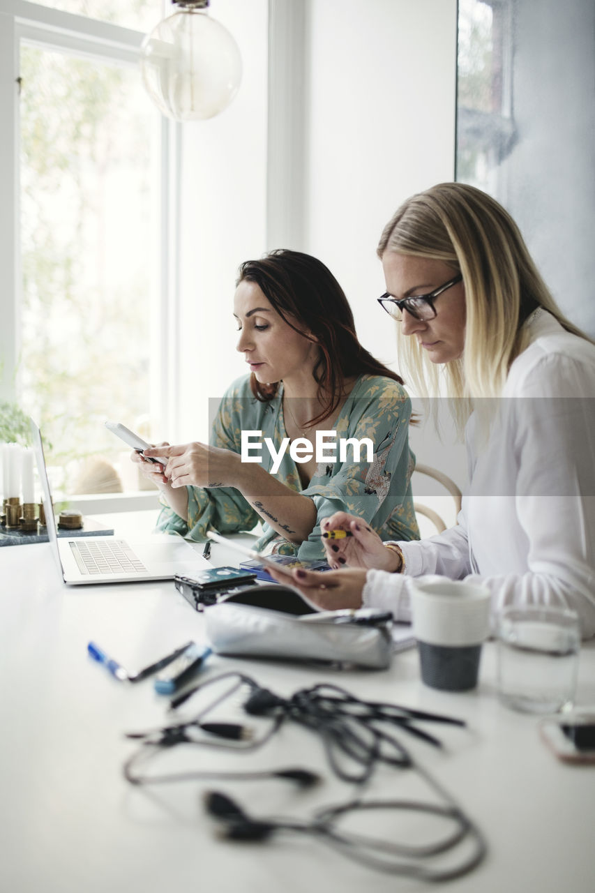 Female colleagues working on table in home office