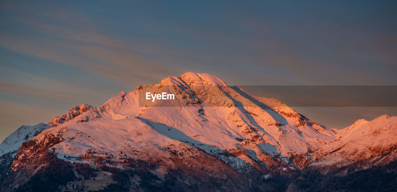 Scenic view of snowcapped mountains against sky during sunset