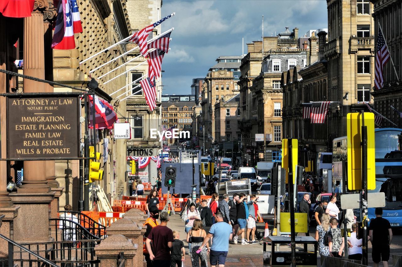 PEOPLE ON CITY STREET AGAINST BUILDINGS