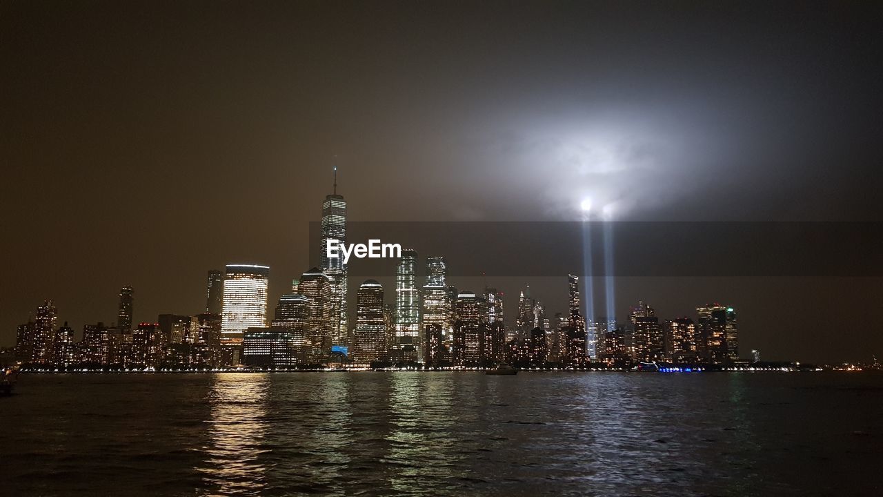 Illuminated buildings in city against sky at night