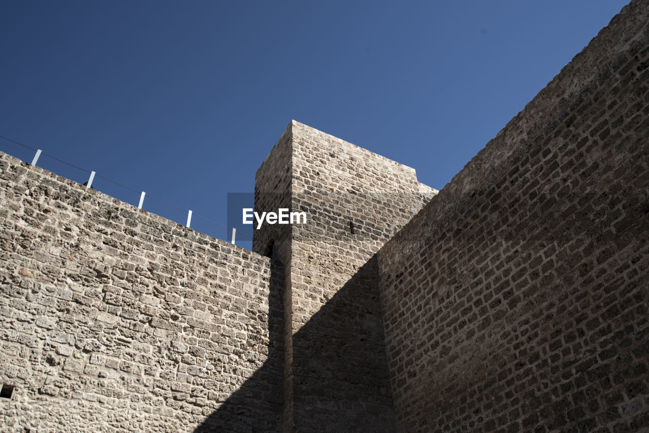 architecture, built structure, wall, sky, building exterior, history, clear sky, the past, nature, wall - building feature, no people, surrounding wall, building, blue, travel destinations, sunny, low angle view, outdoors, fort, brick, travel, sunlight, monument, day, ancient, city, stone material