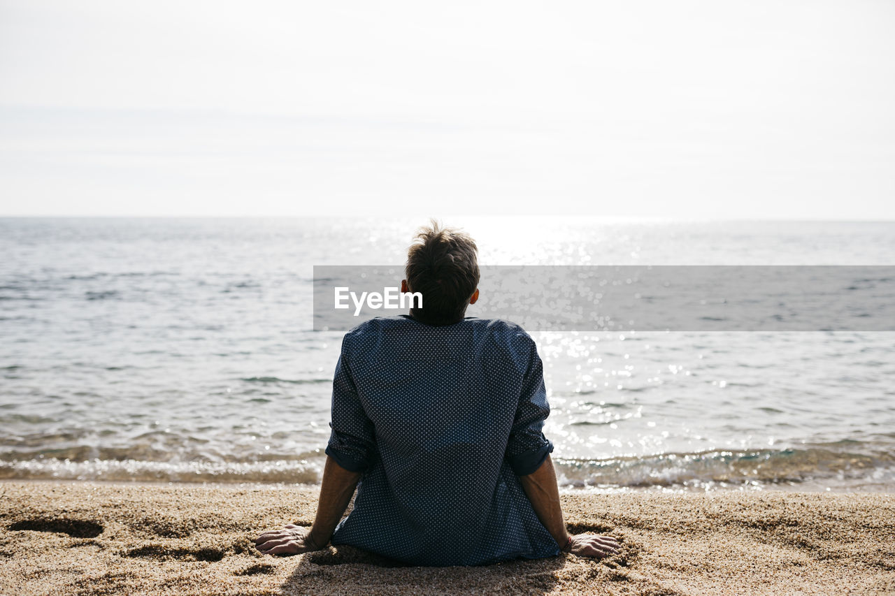 Man relaxing at beach during sunny day