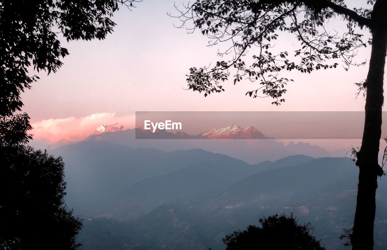 Scenic view of mountains against sky at sunset