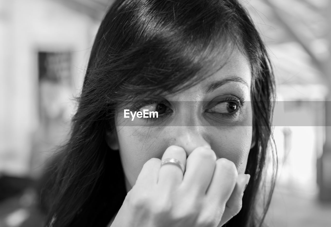 Close-up of beautiful woman covering her mouth