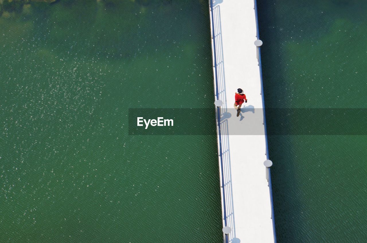 High angle view of man running on pier over sea