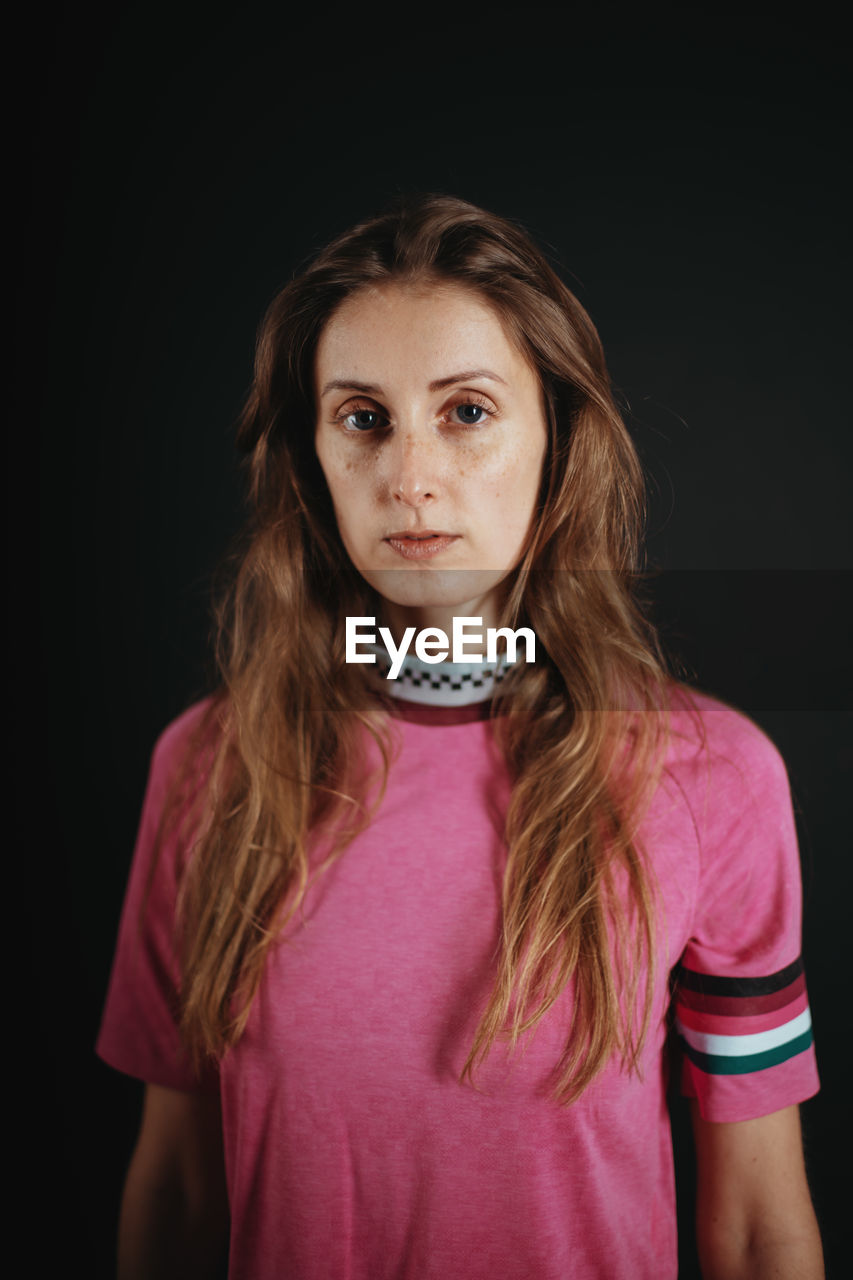 Portrait of a beautiful young woman over black background