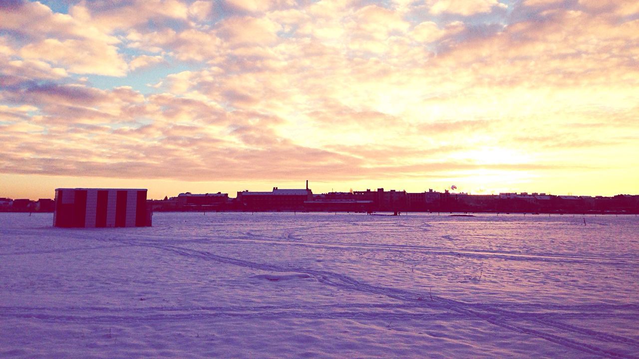 Scenic view of snow covered field against sky during sunset