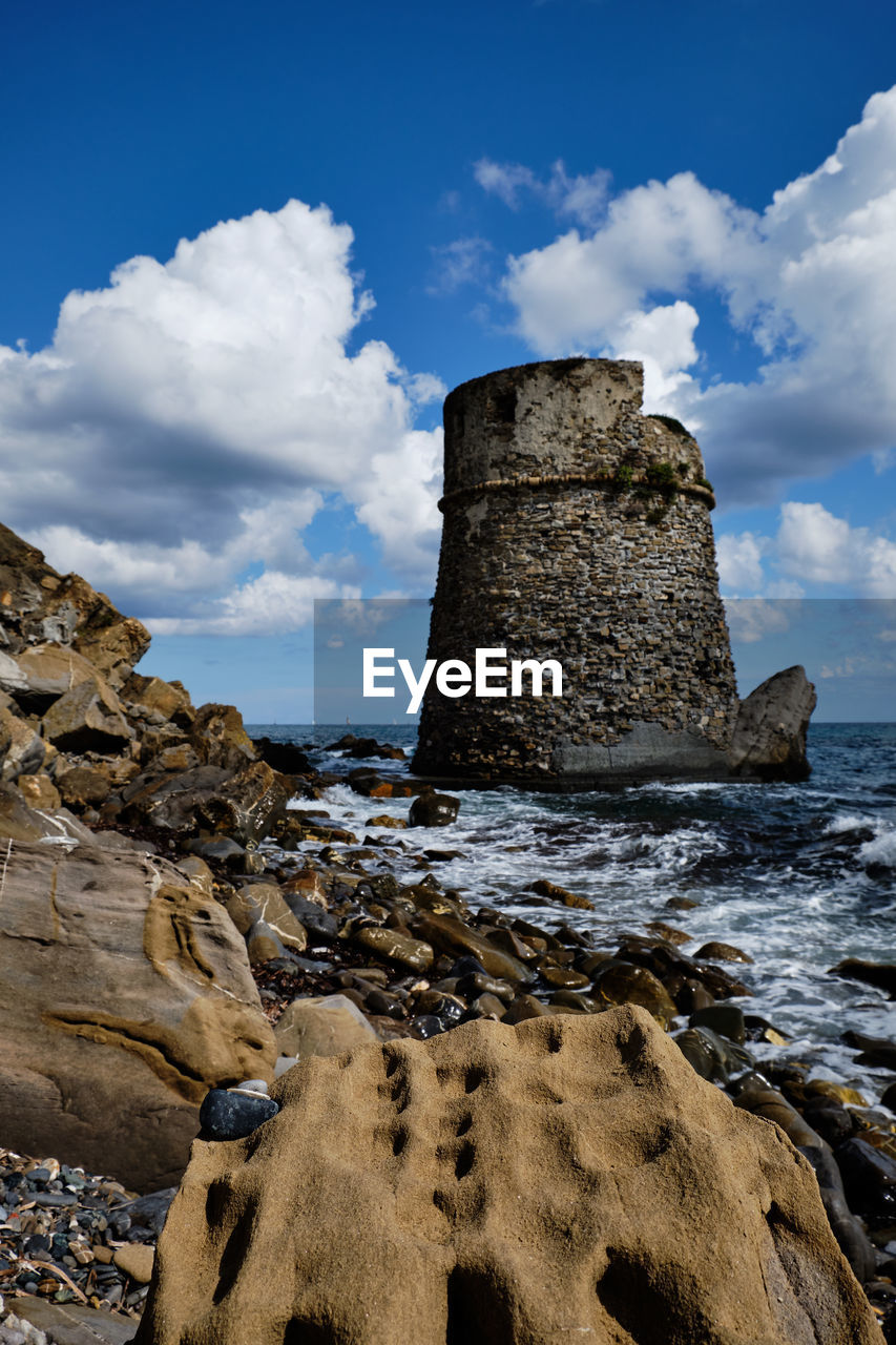 Rock formation on beach against sky