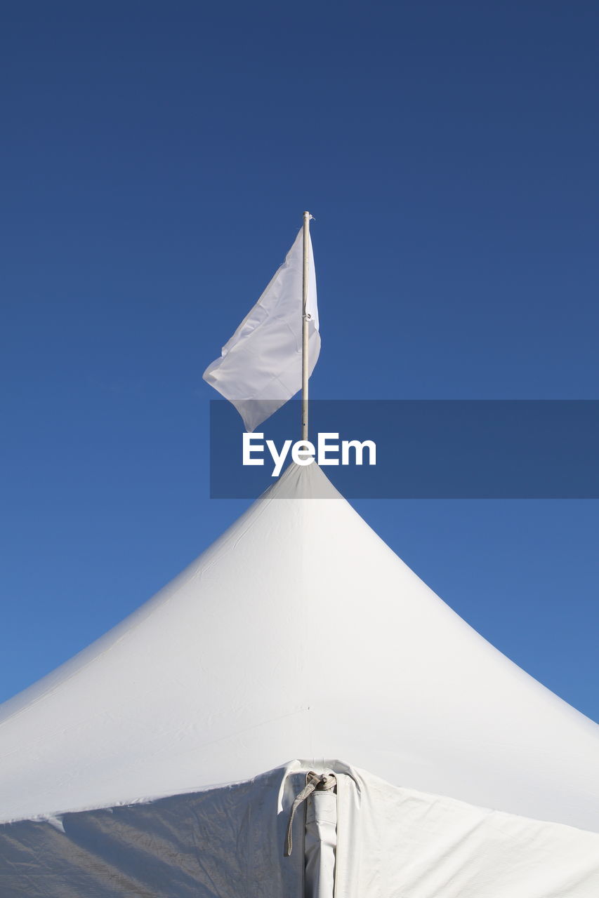 Low angle view of flag against blue sky